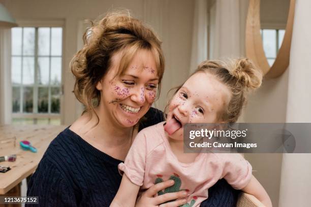 mother and daughter having fun playing dress up at home - apply lipstick stock pictures, royalty-free photos & images