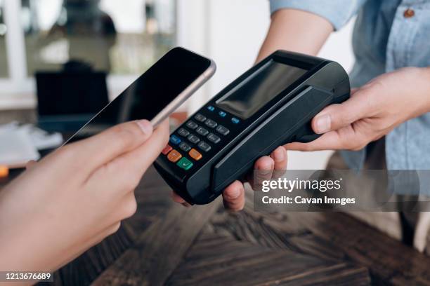 paying bill through smartphone using nfc technology. - nfc payment stock-fotos und bilder