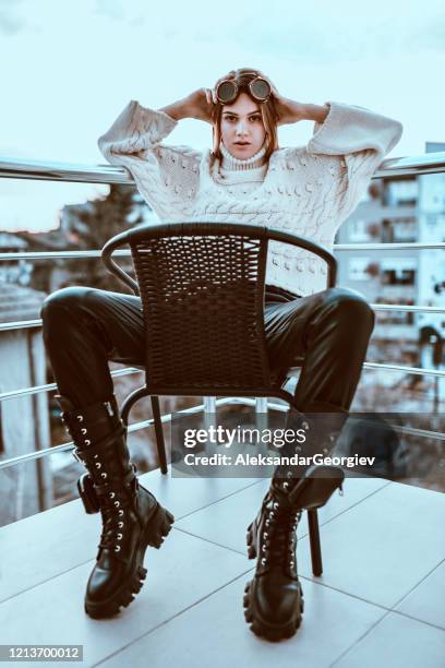 steampunk female beauty sitting on chair on balcony - legs apart imagens e fotografias de stock