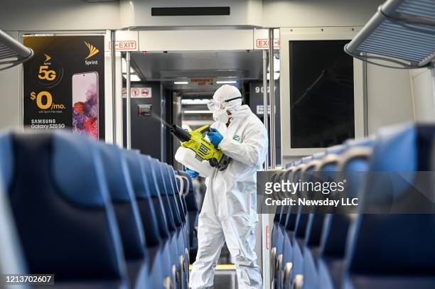 Long Island Rail Road employee disinfects a train car with an eco-friendly cleaner while at the Hicksville, New York LIRR station on March 19, 2020.