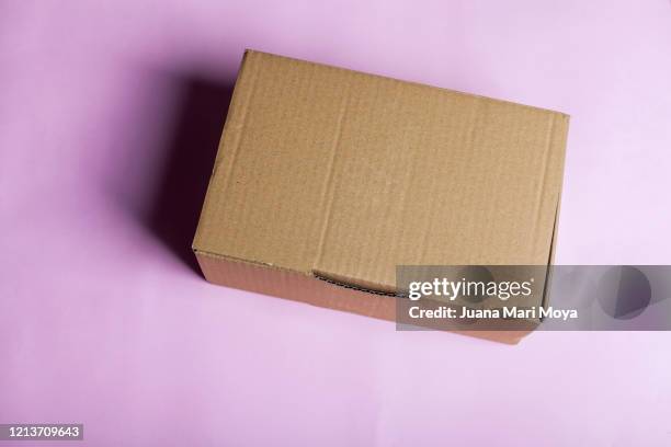 close-up of brown cardboard box on pink background. - cardboard box top view stock pictures, royalty-free photos & images