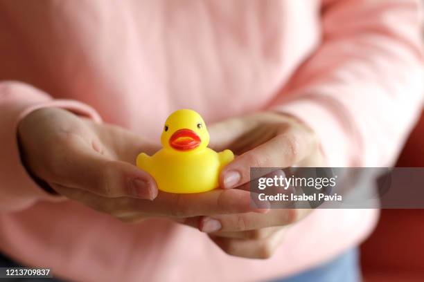 woman hands holding yellow rubber duck - gummiente stock-fotos und bilder