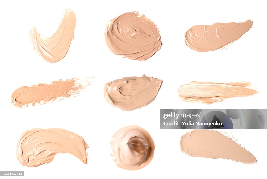 Set of smears of liquid powder, cosmetic make up beige liquid foundation smudges range of colors on white background.