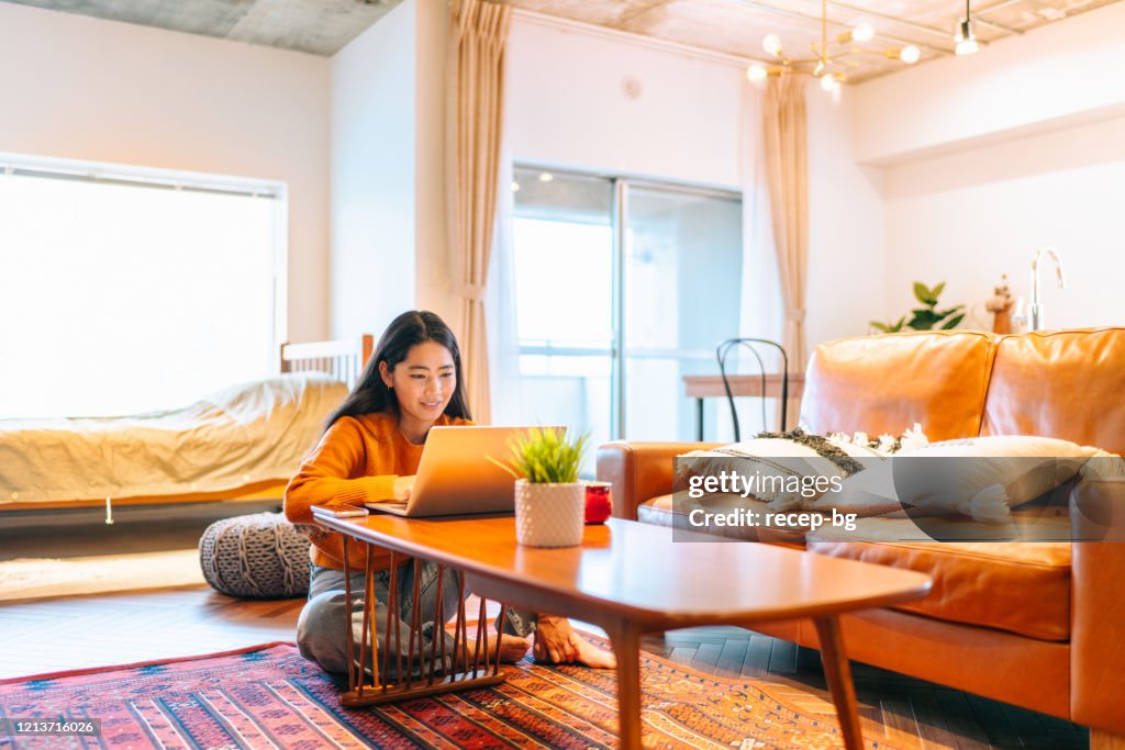 Young woman using laptop comfortably at home