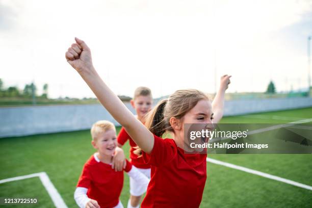 a group of children expressing excitement after a game of soccer. - young girl soccer stock pictures, royalty-free photos & images