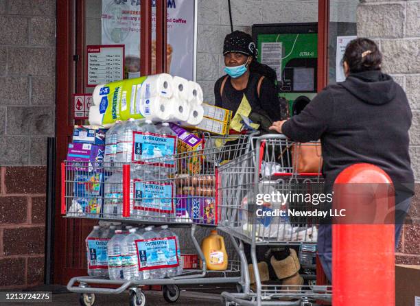 Freeport residents Cortia Morris and her daughter Lashae Haughton leaving BJ's Wholesale Club in Freeport, New York after getting water and paper...