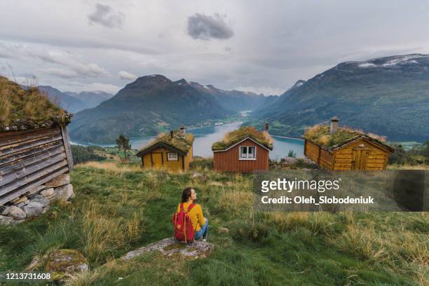 woman sitting near the  huts in moss - hut stock pictures, royalty-free photos & images