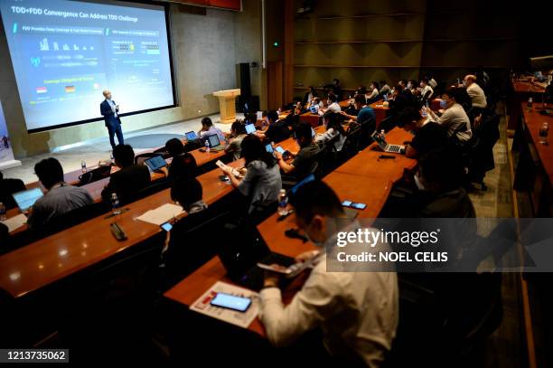 Huawei employees and students listen to a talk during the 5G summit at the Huawei headquarters in Shenzhen in China's southern Guangdong province on...