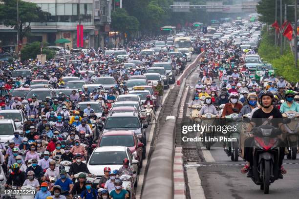 Motorbike riders with face masks are stuck in traffic during the morning peak hour on May 19, 2020 in Hanoi, Vietnam. Though some restrictions remain...