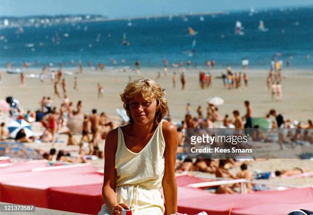 young woman on crowded beach during vacation - 80's retro stockfoto's en -beelden