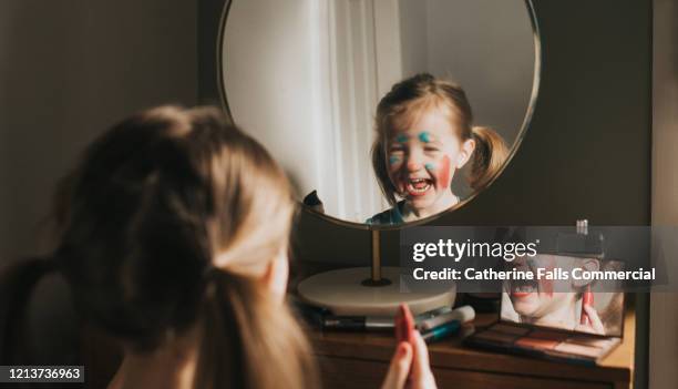 child playing with makeup - bolsa de cor creme fotografías e imágenes de stock