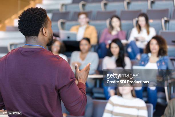 mannelijke gebaren van de universiteitsprofessor tijdens lezing - universiteit stockfoto's en -beelden