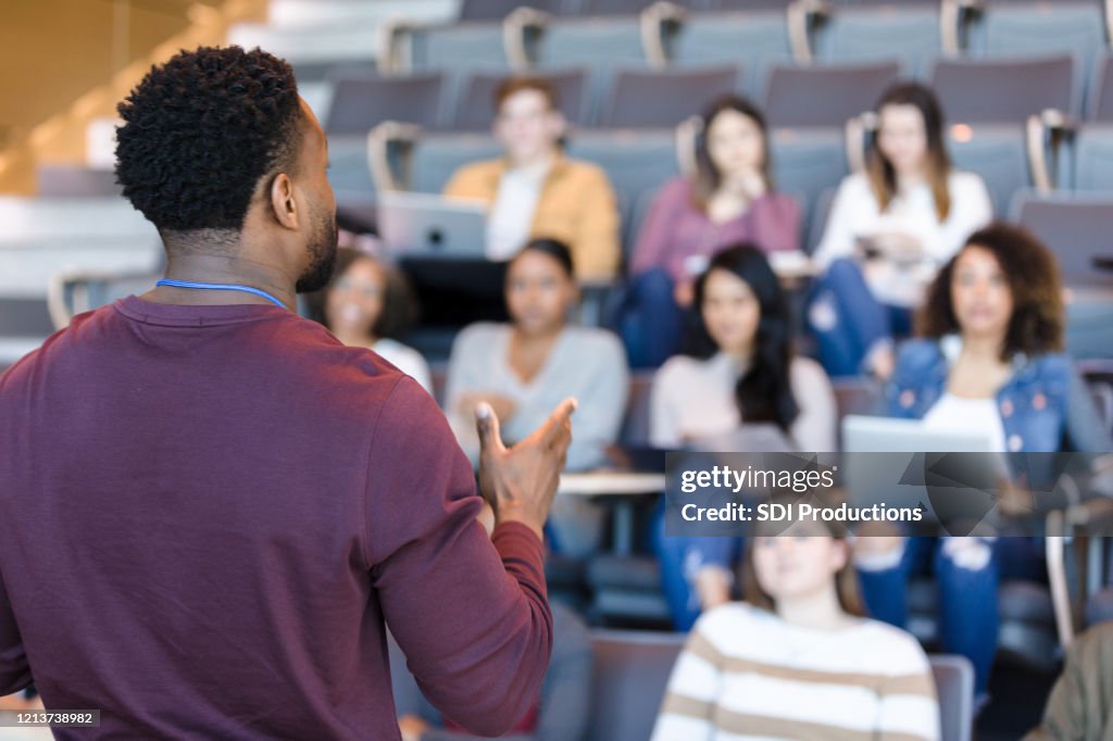Male college professor gestures during lecture