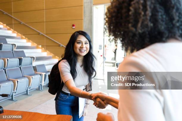 studentin grüßt professorin - students shaking hands stock-fotos und bilder