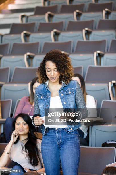 female college student presents paper during class - auditorium seats stock pictures, royalty-free photos & images