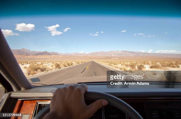 driving a vintage car through death valley national park, california - spring valley road stock pictures, royalty-free photos & images