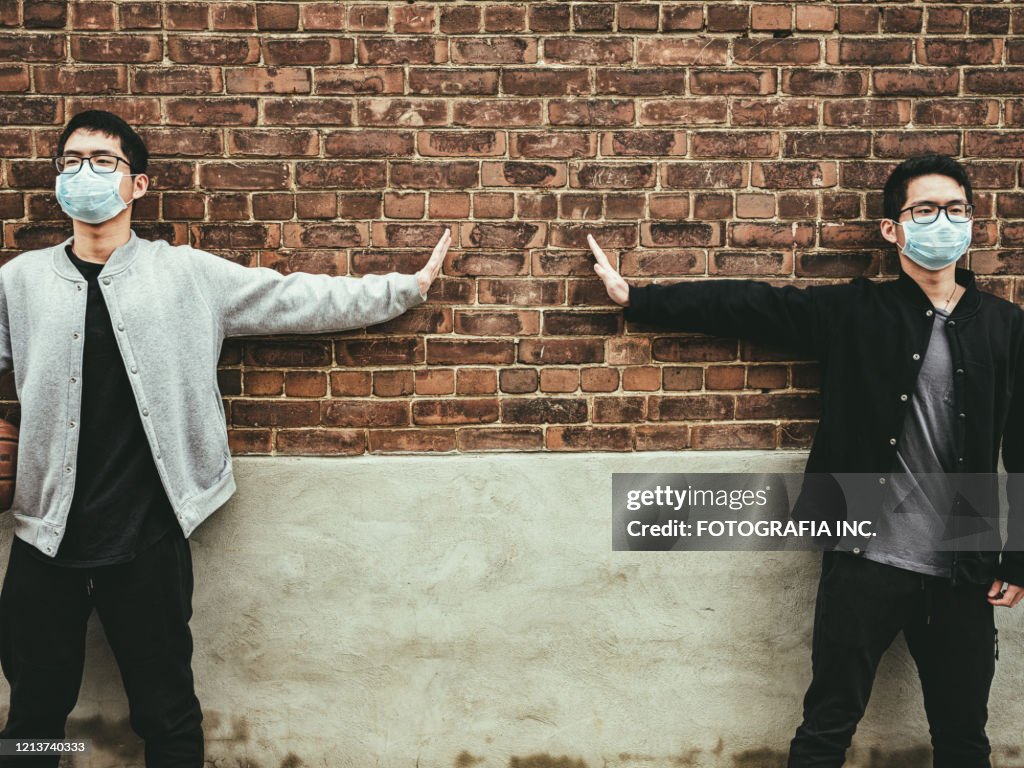 COVID-19 social distancing, Teenagers' hands against outdoor wall