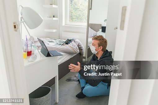 Man in mask meditating in bedroom Man in mask meditating in bedroom