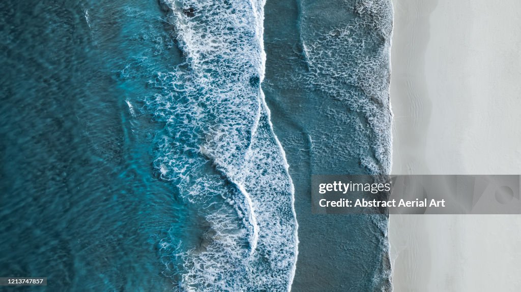 Drone shot showing waves rolling onto a beach, Esperance, Australia