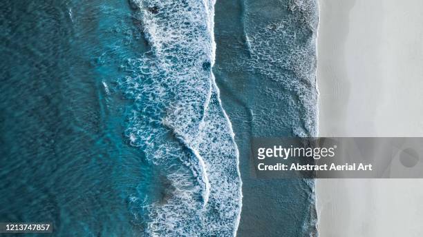drone shot showing waves rolling onto a beach, esperance, australia - litorale foto e immagini stock