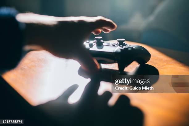 hand grabbing game pad. - manette photos et images de collection