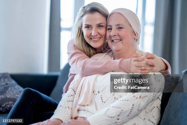 daughter embracing her mother with cancer stock photo - cancer patient with family stock pictures, royalty-free photos & images