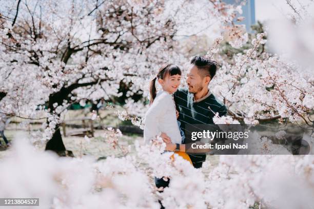 father and young daughter with cherry blossoms, tokyo, japan - cherry blossoms in full bloom in tokyo imagens e fotografias de stock