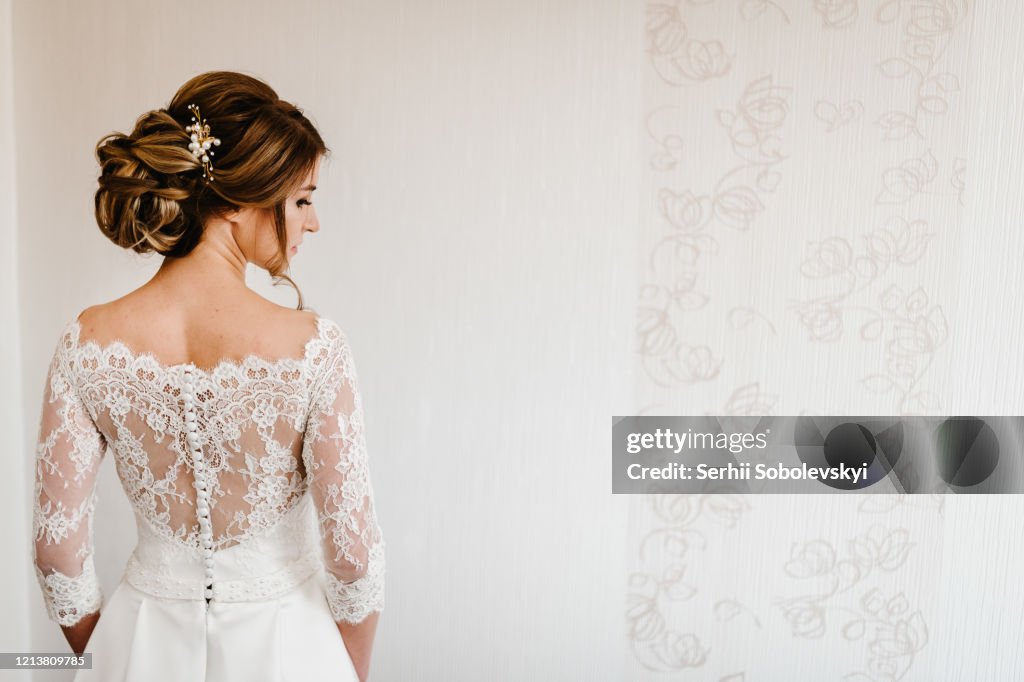 Retrato de uma linda noiva elegante com uma elegante vista de penteado de trás. Casamento, pessoas, conceito de moda e beleza- noiva em vestido de noiva. Vista para trás.