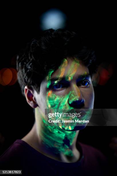 guy portrait painted with uv makeup color - crazy holiday models - fotografias e filmes do acervo