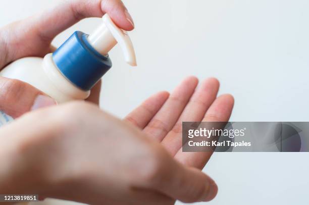 a young female is using a moisturizing lotion - freshness guard stock pictures, royalty-free photos & images
