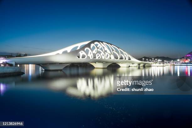 modern bridge structure at night - qingdao photos et images de collection