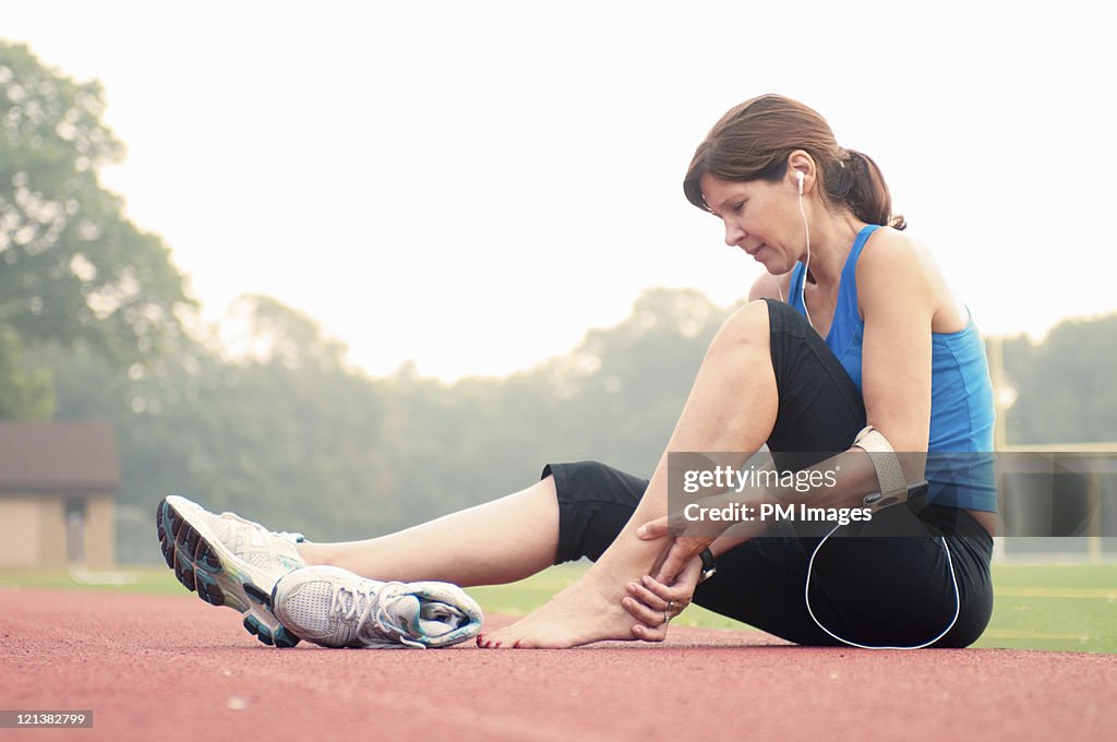 Woman jogger holding injured ankle