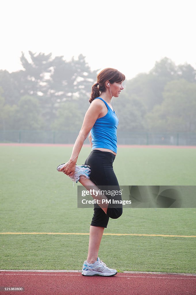 Woman stretching on running track