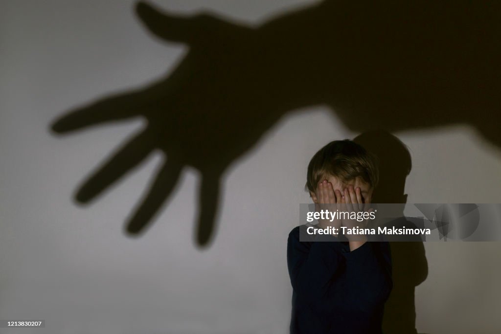 Little boy and scary shadow of hand