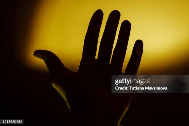 hands silhouette in dark - yellow light stock pictures, royalty-free photos & images