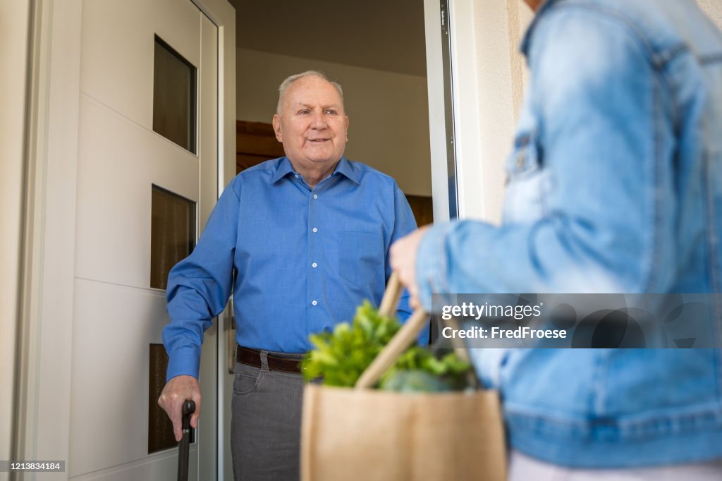 Quarantäne – Frau hilft Senior-Mann