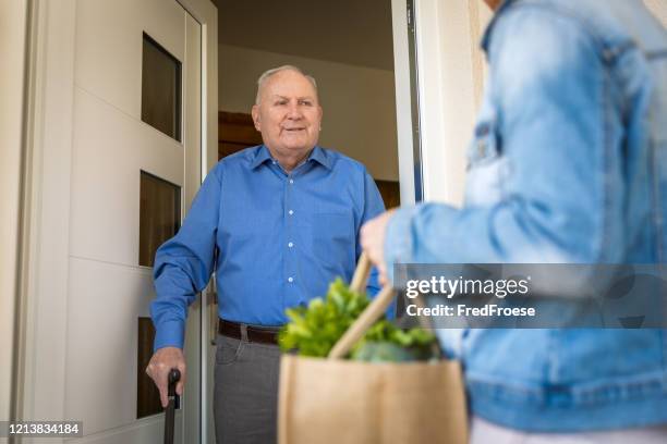 quarantine – woman helping senior man - covid shopping stock pictures, royalty-free photos & images