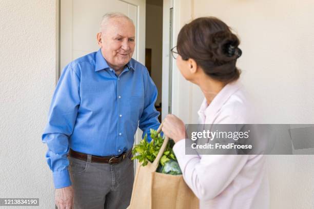 quarantine – woman helping senior man - aged care covid stock pictures, royalty-free photos & images