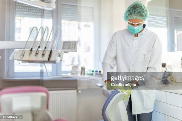 female doctor cleaning dental office - rubbing stock pictures, royalty-free photos & images