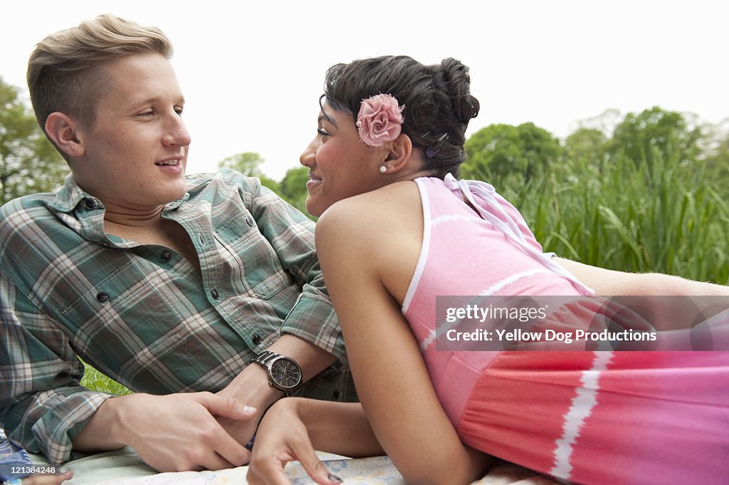 Couple sitting together on a blanket outdoors