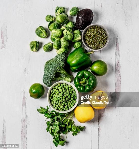 green vegetables on white, wooden background - legume vert photos et images de collection