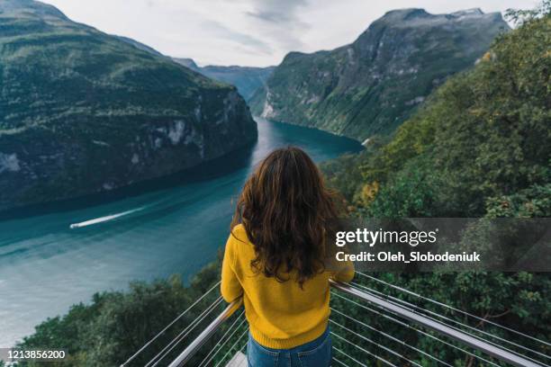 woman looking at cruise liners  on  geirangerfjord in norway - geiranger stock pictures, royalty-free photos & images