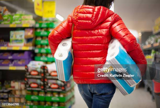 woman at the supermarket, buying paper towels in abundance for lack of toilet paper - panic buying fotografías e imágenes de stock