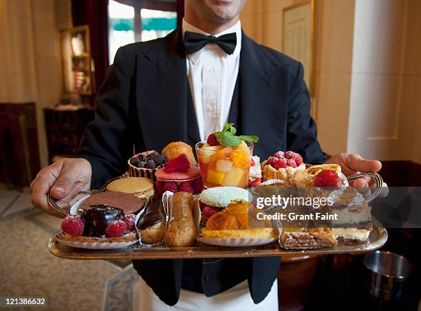 waiter displaying french desserts on tray - kellner tablett stock-fotos und bilder