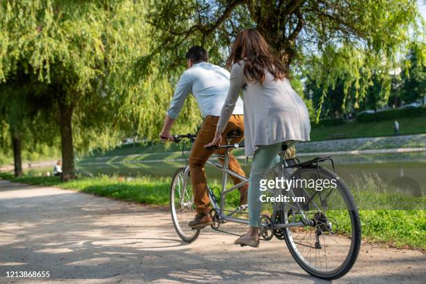 par rider en tandemcykel på en flodbank - tandem bicycle bildbanksfoton och bilder