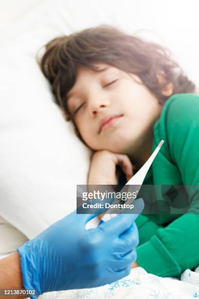 doctor checking on sick her son laying in bed - thermometer turkey stock pictures, royalty-free photos & images