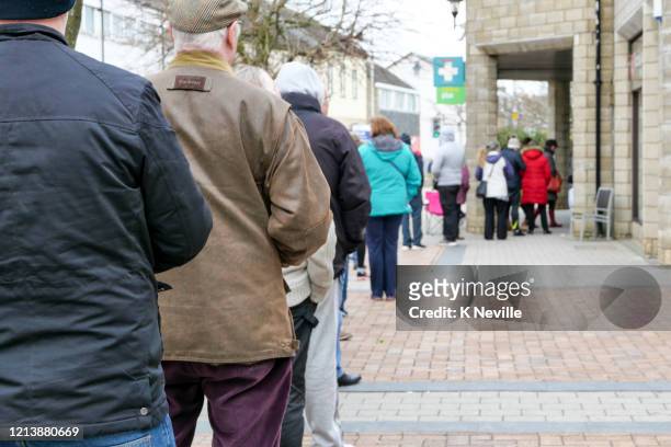 queue of people trying to get their prescriptions, as people panic over coronavirus - lining up imagens e fotografias de stock