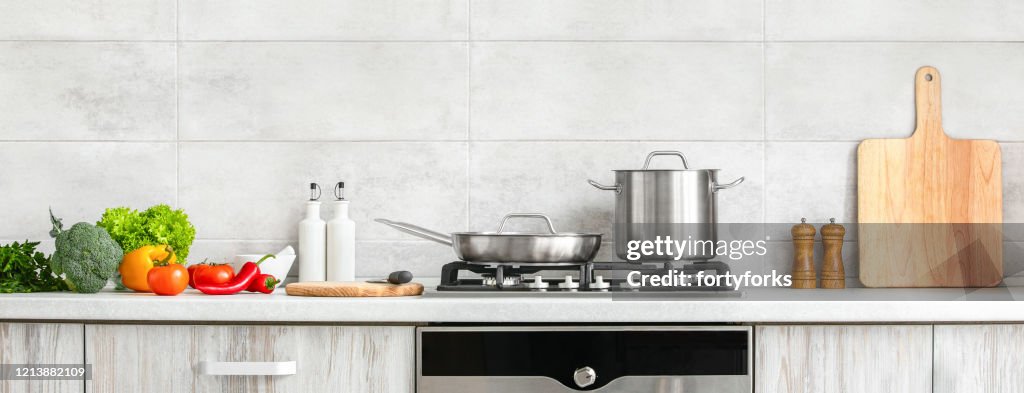 Modern kitchen countertop with domestic culinary utensils on it, home healthy cooking concept banner