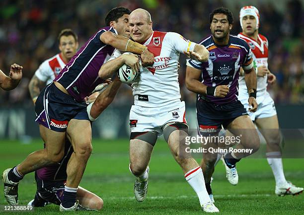 Michael Weyman of the Dragons is tackled by Jesse Bromwich of the Storm during the round 24 NRL match between the Melbourne Storm and the St George...