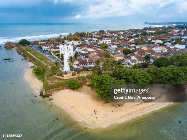 aerial view of galle lighthouse and galle fort walls in the bay of galle on the southwest coast of sri lanka. - galle fort stock pictures, royalty-free photos & images